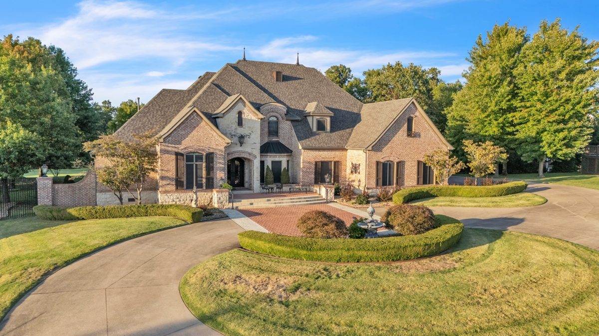 Brick estate home exterior with circular driveway and manicured landscaping — real estate exterior photography by Oakmont Visuals